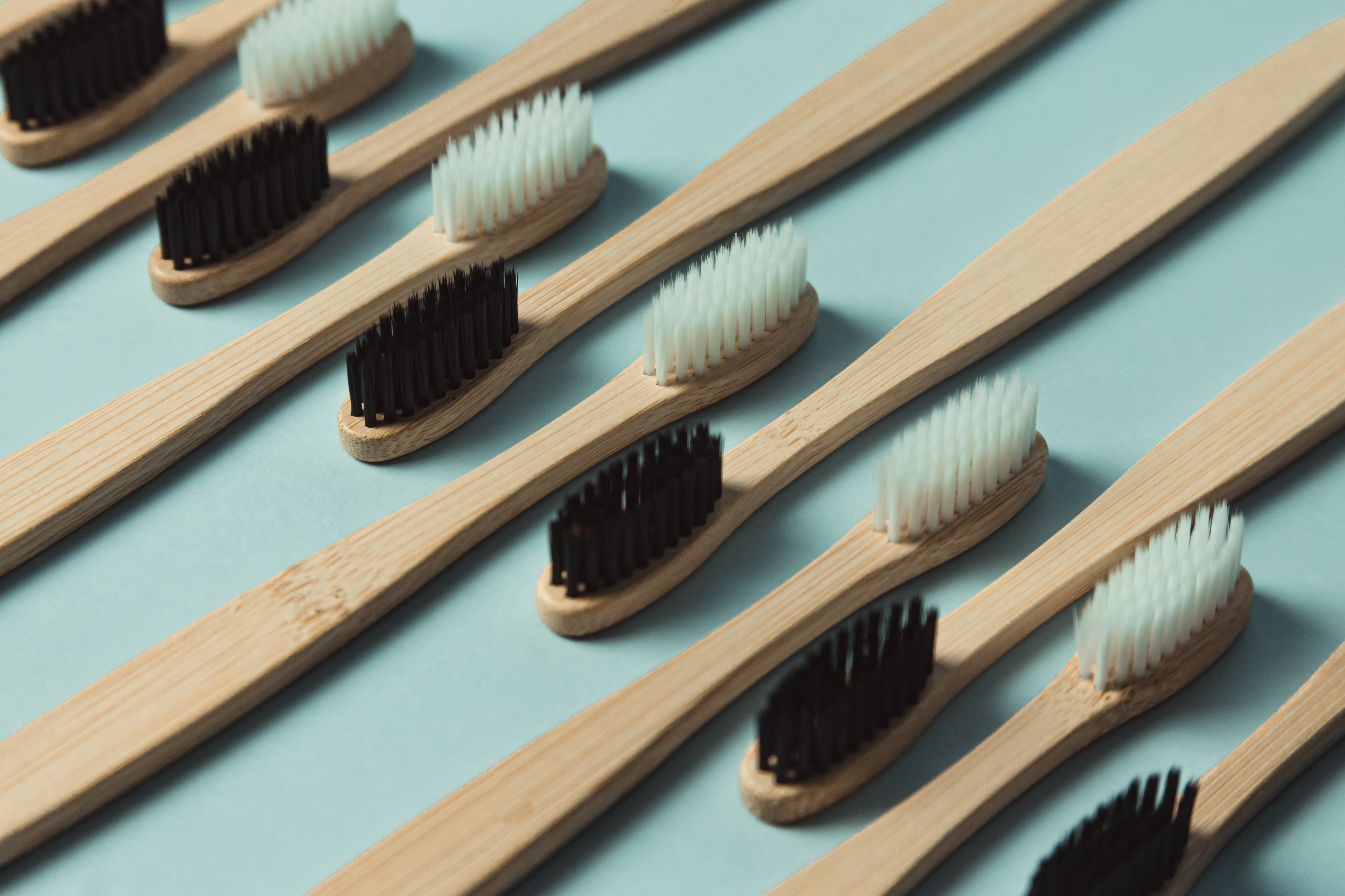 files/wooden-toothbrushes-lined-up-against-a-green-background.jpg